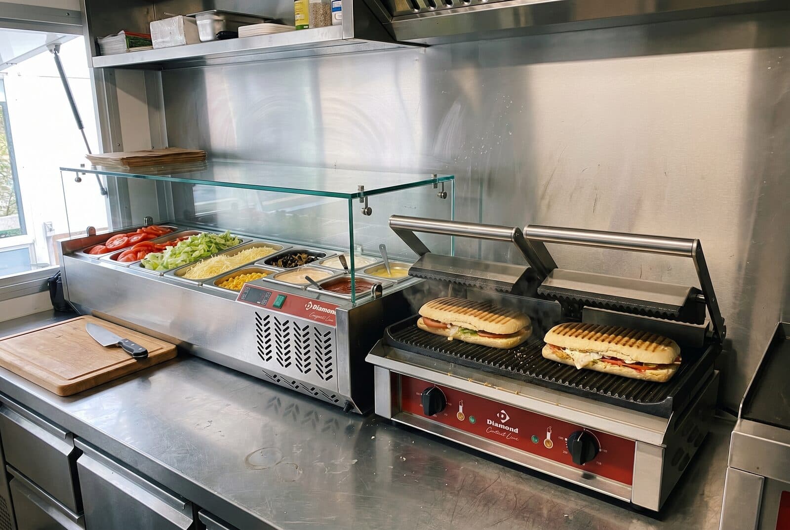 Saladette réfrigérée garnie et grill panini dans la zone de préparation d'un food truck